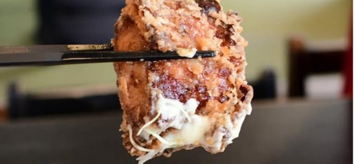 箸で持ち上げた、揚げたての大きな唐揚げ